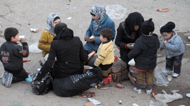 Refugiados de Alepo comen un poco para recuperar fuerzas.