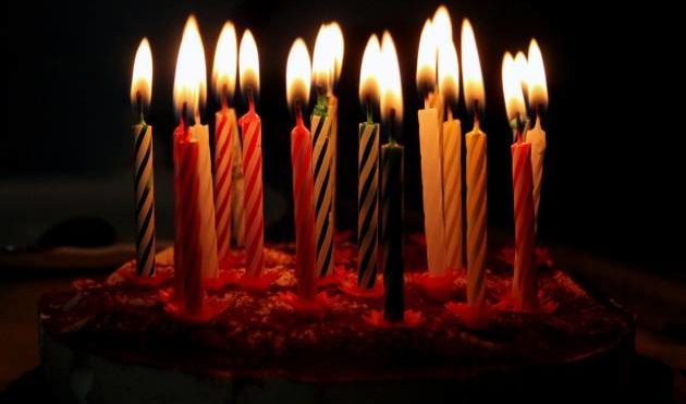 Pastel con velas de colores encendidas
