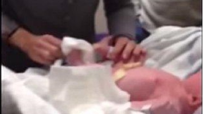 manos de una mujer junto a un bebé recién nacido
