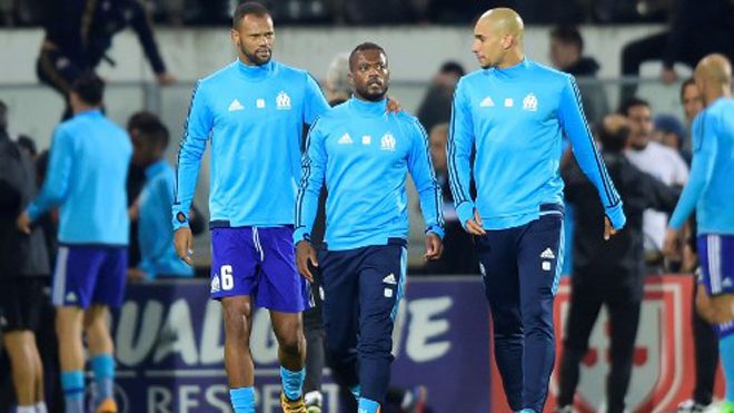 Marseille's French defender Patrice Evra (C) is escorted off the pitch by teammates Portuguese defender Rolando and Brazilian defender Doria after an argument with supporters before the start of the UEFA Europa League group I football match Vitoria SC vs Marseille at the D. Afonso Henriques stadium in Guimaraes on November 2, 2017. MIGUEL RIOPA / AFP