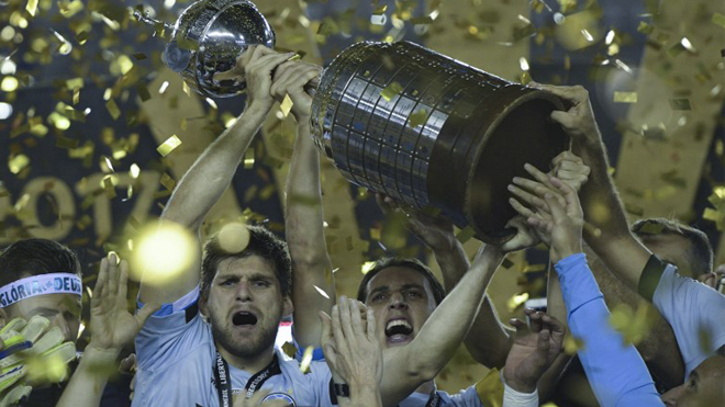 Brazil's Gremio footballers celebrate with the trophy after winning the Copa Libertadores 2017 final football match against Argentina's Lanus at Lanus stadium in Lanus, Buenos Aires, Argentina, on November 29, 2017. Gremio won 2-1 to become the champion of the Copa Libertadores 2017. JUAN MABROMATA / AFP