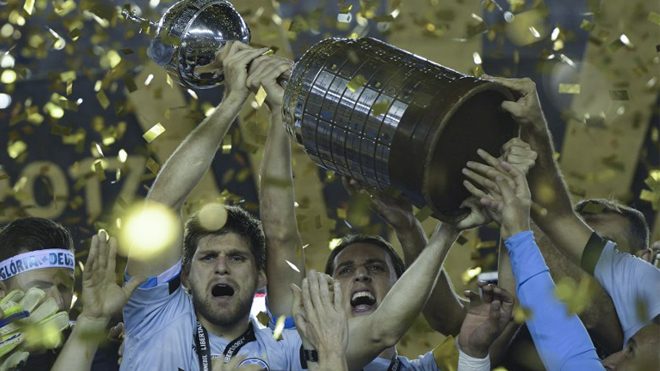Brazil's Gremio footballers celebrate with the trophy after winning the Copa Libertadores 2017 final football match against Argentina's Lanus at Lanus stadium in Lanus, Buenos Aires, Argentina, on November 29, 2017. Gremio won 2-1 to become the champion of the Copa Libertadores 2017. JUAN MABROMATA / AFP