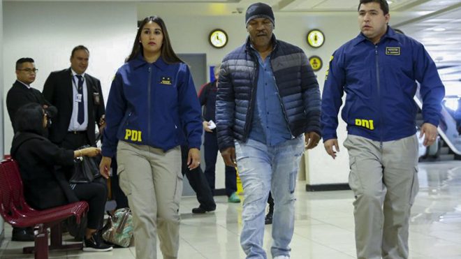 Handout picture realesed on November 9, 2017 by Chile's Investigation Police showing US former world heavyweight boxing champion Mike Tyson escorted by Chile's Investigations Police