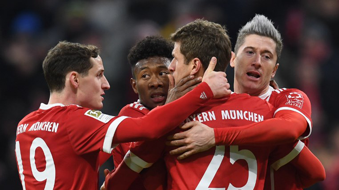 (LtoR) Bayern Munich's Austrian defender David Alaba, striker Thomas Mueller and Polish striker Robert Lewandowski celebrate after the first goal during the German first division Bundesliga football match between FC Bayern Munich and FC Cologne on December 13, 2017 in Munich. Christof STACHE / AFP