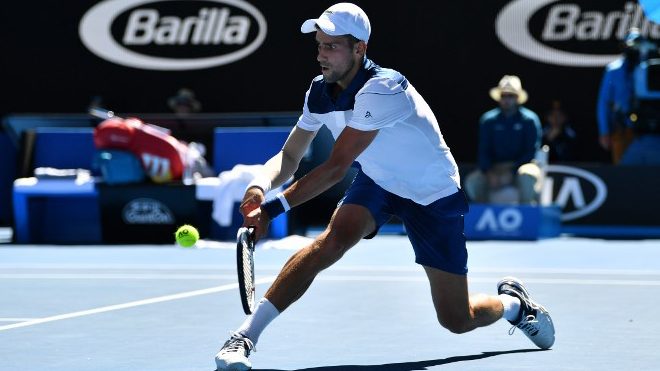 Serbia's Novak Djokovic hits a return against France's Gael Monfils during their men's singles second round match on day four of the Australian Open tennis tournament in Melbourne on January 18, 2018. SAEED KHAN / AFP