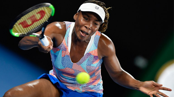 Venus Williams of the US hits a return against Switzerland's Belinda Bencic during their women's singles first round match on day one of the Australian Open tennis tournament in Melbourne on January 15, 2018. GREG WOOD / AFP