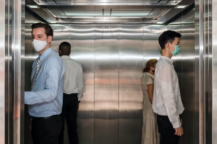 Personas en un ascensor durante la crisis del coronavirus