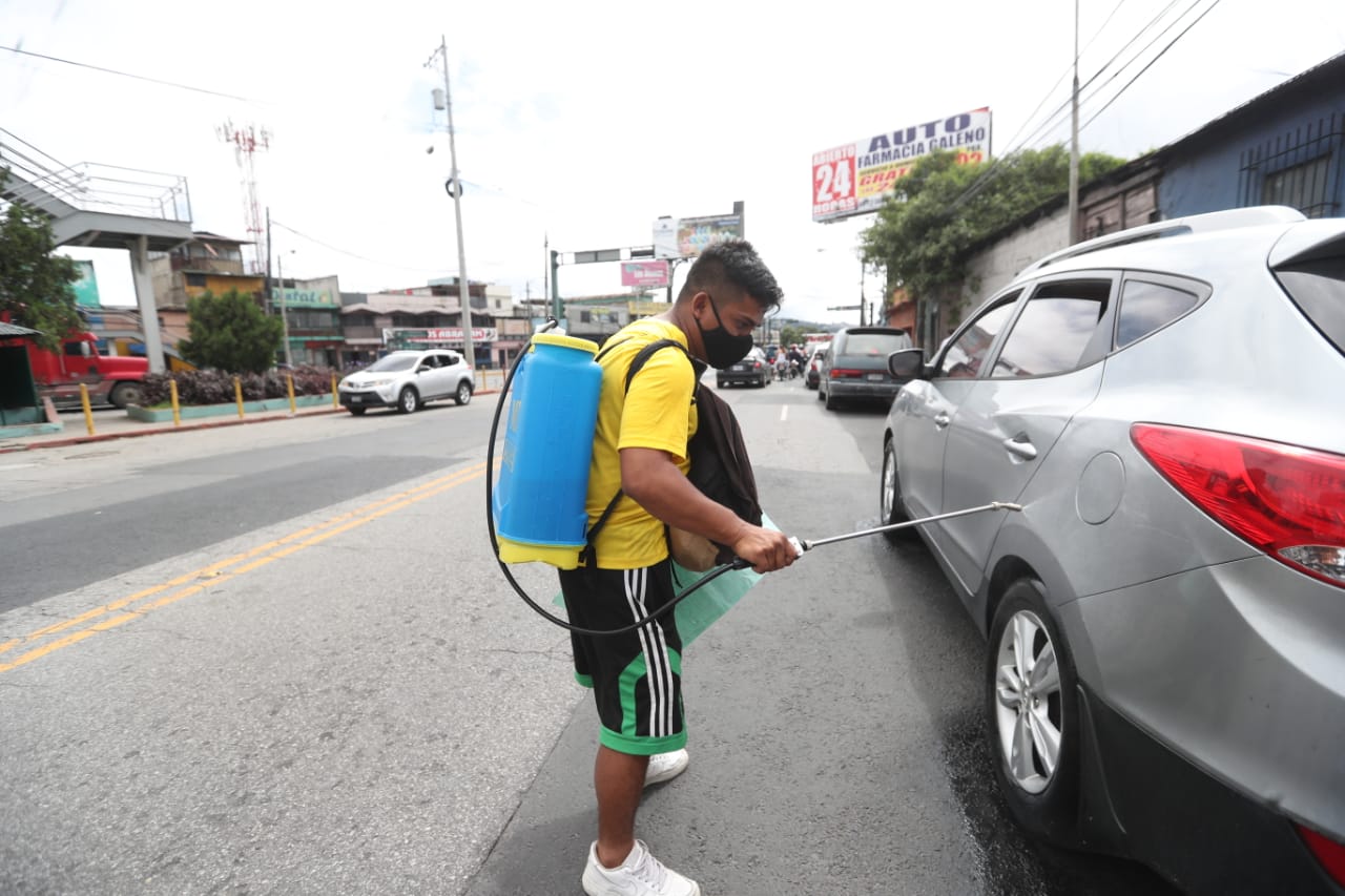 “Con tres hijos y sin empleo, tengo que ver cómo salgo adelante”: padre desinfecta vehículos en calles de la zona 6 capitalina ante la crisis del coronavirus