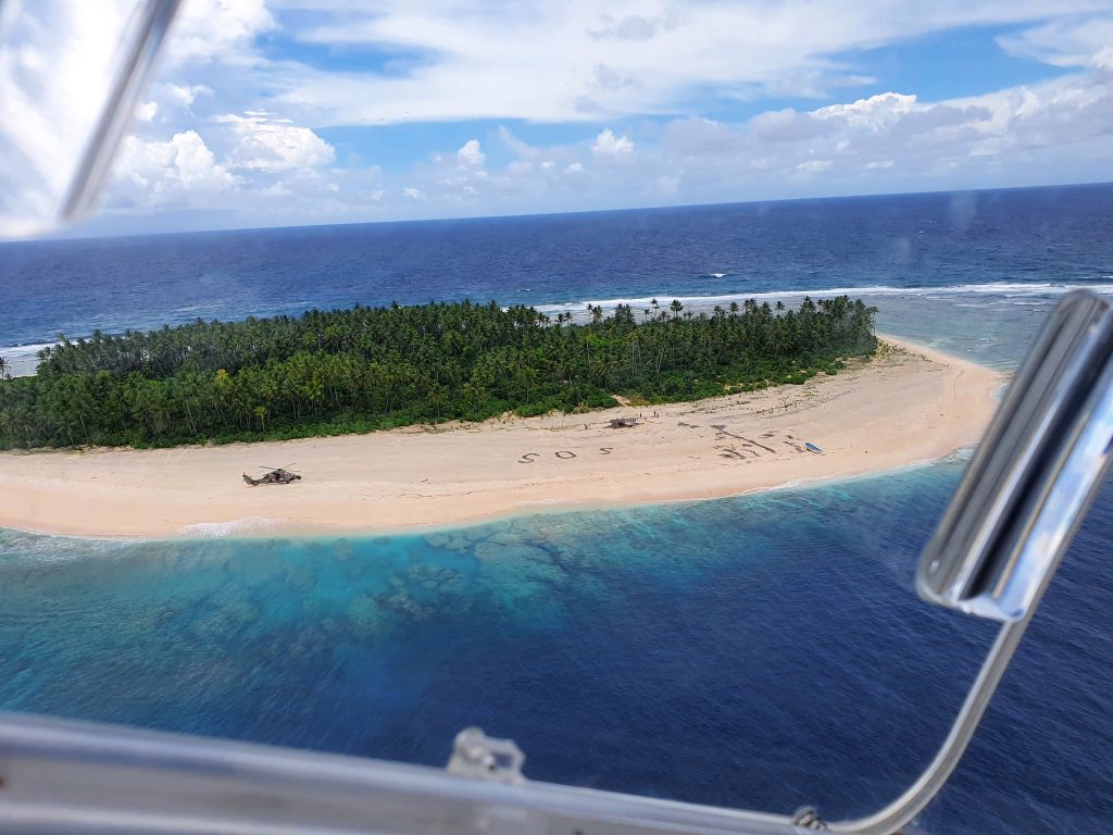 Como escena de película: rescatan a tres hombres perdidos en isla desierta del Pacífico tras escribir en la arena SOS