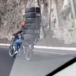 Graban el riesgoso momento en que un motorista transporta seis llantas sujetas con una faja
