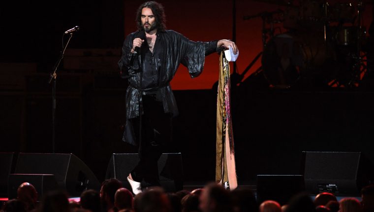 (FILES) Host British actor Russell Brand speaks onstage during the 2020 MusiCares Person Of The Year gala honoring US rock band Aerosmith at the Los Angeles Convention Center in Los Angeles on January 24, 2020. British comedian and actor Russell Brand has been accused of rape, sexual assaults and emotional abuse during a seven-year period, according to the results of a media investigation published on September 16, 2023. (Photo by MARK RALSTON / AFP)