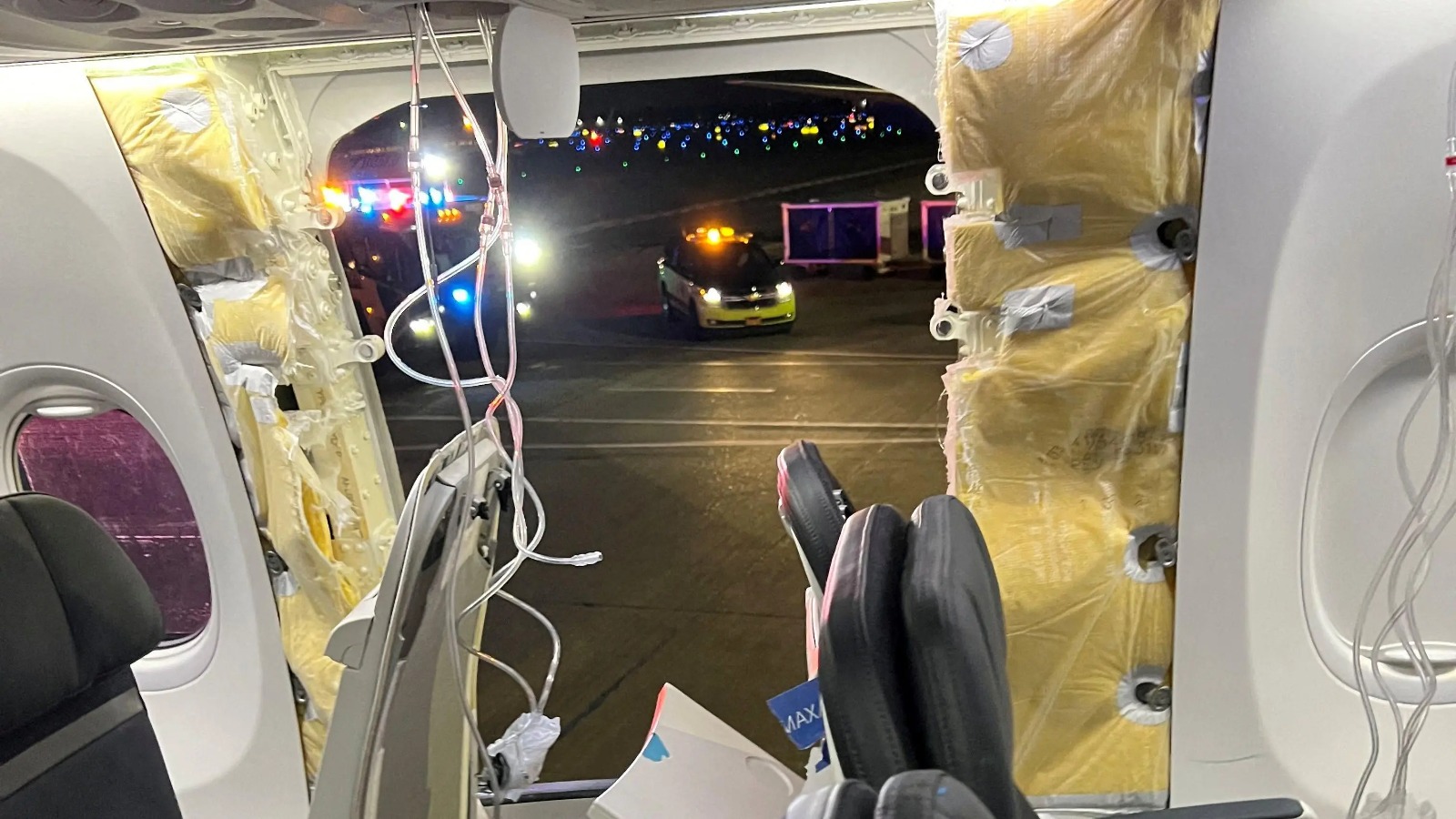 Las máscaras de oxígeno en el techo del avión Alaska Airlines junto a la parte de la puerta faltante.